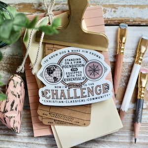 May include: A sticker with a pink and white design. The sticker says "To know God & make him known." and "Standing on a firm foundation and equipped with the essentials. Now I'm rising to the challenge. Christian-Classical-Community."
