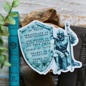 May include: A blue and white sticker featuring a knight in armour holding a sword. The sticker has a shield with the text "Belt of Truth, Breastplate of Righteousness, The Gospel of Peace Strapped to Your Feet, Shield of Faith, Helmet of Salvation, Sword of the Spirit" and "Ephesians 6:10-15".