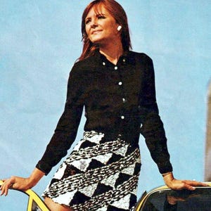 Peut inclure: Une chemise noire à manches longues boutonnée associée à une jupe courte avec un motif géométrique de triangles noirs et blancs. La jupe a un aspect texturé et la chemise possède des boutons blancs. Le texte sur l'image indique Compiled and Digitised by Aussie Sewing & Craft.