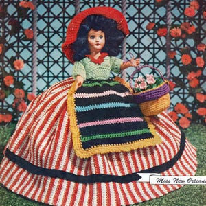 May include: Cover of "Dolls of the Americas" featuring a doll in a red and white striped dress, green top, and red hat. The doll holds a basket of flowers. Text includes "DOLLS OF THE AMERICAS" and "Miss New Orleans".