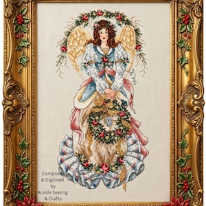 May include: A cross-stitch embroidery of an angel with brown hair, gold wings, and a blue and white dress, holding a floral wreath with a small koala. The piece is framed in an ornate gold frame with holly and poinsettia details. Text reads: Compiled & Digitised by Aussie Sewing & Crafts.