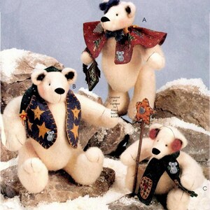 May include: Three cream-coloured plush bears labelled A, B, and C. Bear A wears a red patterned cape. Bear B wears a dark blue vest with yellow stars. Bear C holds a star-shaped wand and wears a dark scarf. Text reads Compiled and Digitised by Aussie Sewing & Craft.