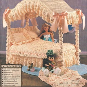 May include: A crocheted doll bed with a canopy, featuring a peach-colored design. The bed includes a ruffled skirt, reversible comforter, and pillow shams. Decorative bows and dolls are included, creating a charming, handmade aesthetic.