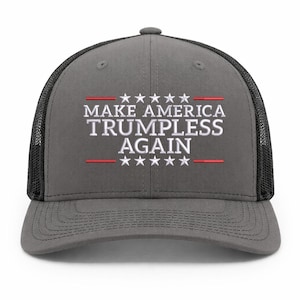 May include: Gray trucker hat with a black mesh back. The front of the hat features the text "MAKE AMERICA TRUMPLESS AGAIN" in white, with red lines and stars above and below the text. A political statement.