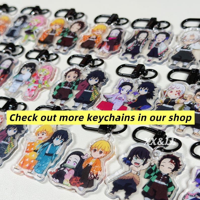 K&ouml;nnte beinhalten: Eine Sammlung von Anime-Charakter-Schl&uuml;sselanh&auml;ngern mit schwarzen Metallverschl&uuml;ssen. Die Schl&uuml;sselanh&auml;nger zeigen farbenfrohe Illustrationen verschiedener Charaktere. Text auf einem gelben Banner: "Check out more keychains in our shop."