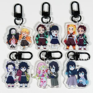 May include: Nine acrylic keychains featuring anime characters with black metal clasps. The keychains showcase various characters in colorful outfits, with detailed facial expressions and poses. Each keychain is approximately 2 inches in height.