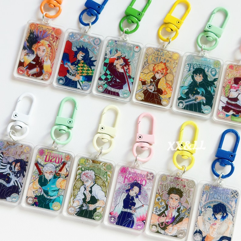 K&ouml;nnte beinhalten: Eine Sammlung rechteckiger Acryl-Schl&uuml;sselanh&auml;nger mit Anime-Charakteren. Jeder Schl&uuml;sselanh&auml;nger hat ein anderes Charakterdesign mit leuchtenden Farben und einem farblich passenden Verschluss. Die Schl&uuml;sselanh&auml;nger sind an einer Vielzahl farbiger Verschl&uuml;sse befestigt, darunter Orange, Blau, Gr&uuml;n und Gelb.