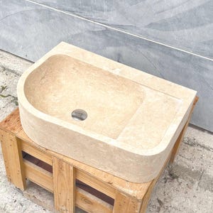 CNC machining process of a travertine marble sink in workshop environment