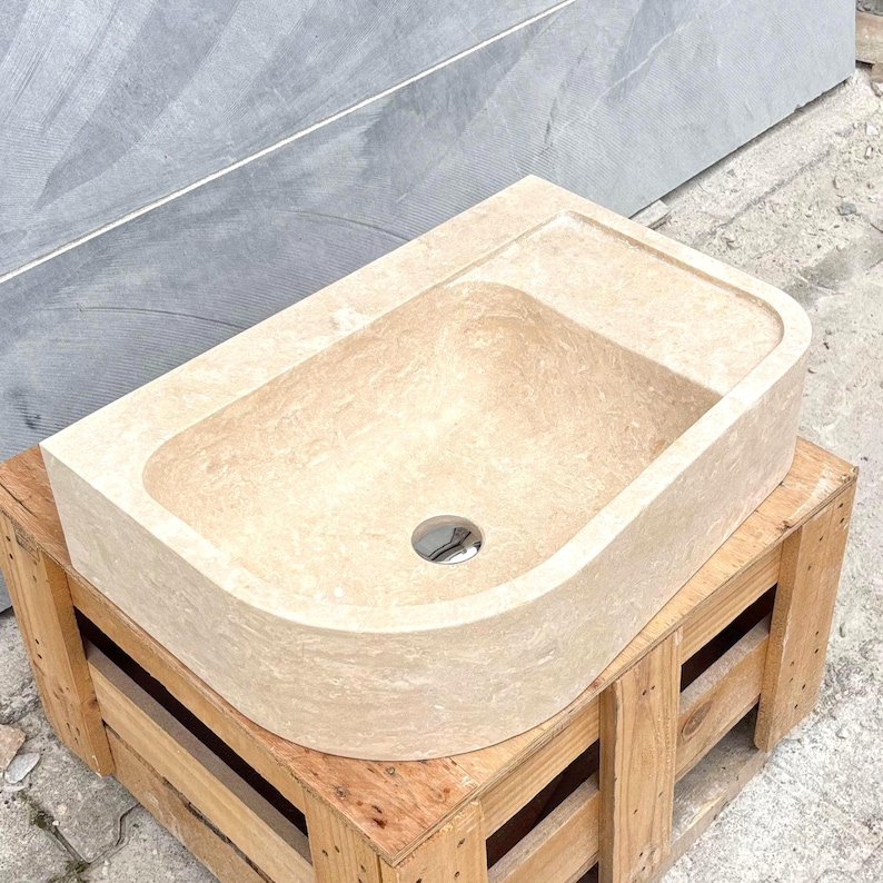 travertine marble sink displayed on a wooden pallet from top angle