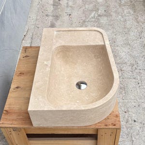 Side profile view of thick edge travertine marble sink