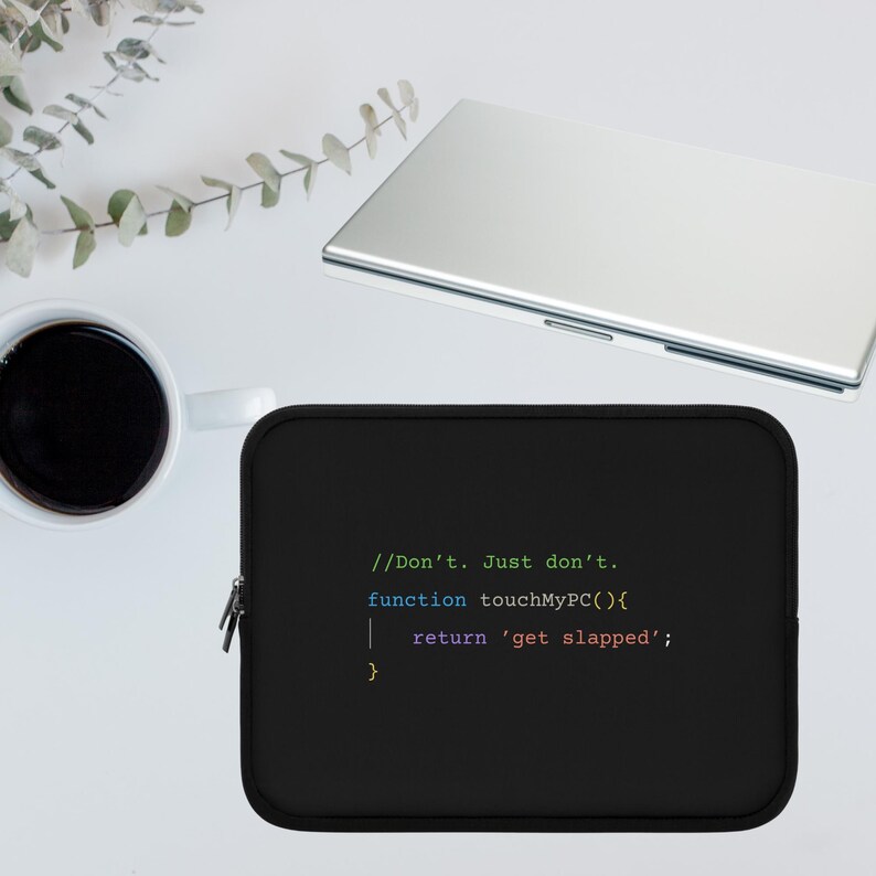以下が含まれることがあります： 「//Don't. Just don't. function touchMyPC(){ return 'get slapped'; }」というテキストがカラフルなコードのようなフォントで書かれた黒いラップトップスリーブ。シルバーのノートパソコン、白いコーヒーマグ、緑の植物が背景にあります。