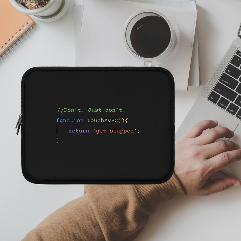 以下が含まれることがあります： 「//Don't. Just don't.」のテキストとコードスニペットがプリントされた黒いラップトップスリーブ。長方形のスリーブにはジッパーが付いています。背景にはノートパソコン、コーヒーカップ、ノートがあります。