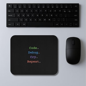 May include: Black computer mouse, keyboard, and mousepad. The mousepad has rounded corners and the words "Code. Debug. Cry. Repeat." in green, blue, purple, and red. The keyboard is black with white lettering.