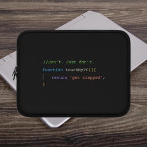 以下が含まれることがあります： 黒いラップトップケース。カラフルなコードのようなフォントで「//Don't. Just don't. function touchMyPC(){ return 'get slapped'; }」と書かれています。長方形のケースは、ラップトップが置かれた木製の表面にあります。