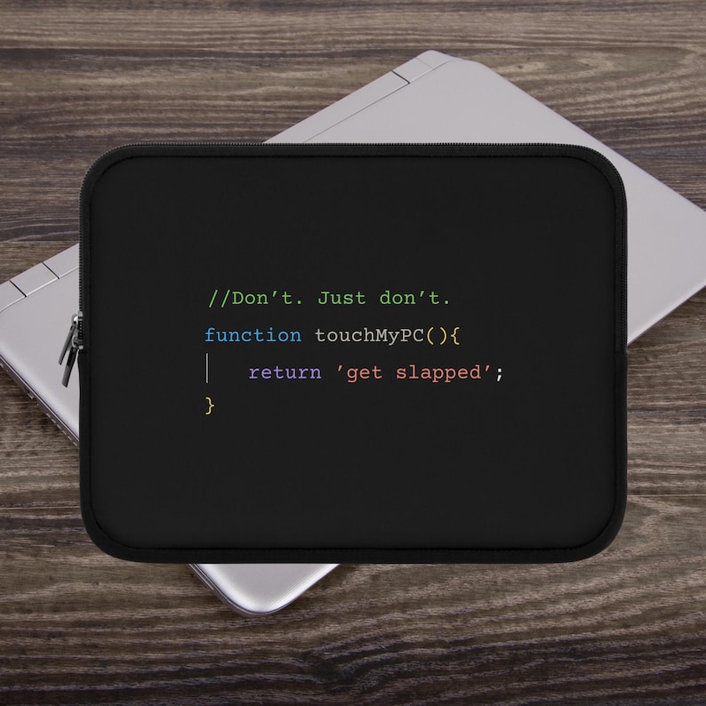 以下が含まれることがあります： 黒いラップトップケース。カラフルなコードのようなフォントで「//Don't. Just don't. function touchMyPC(){ return 'get slapped'; }」と書かれています。長方形のケースは、ラップトップが置かれた木製の表面にあります。