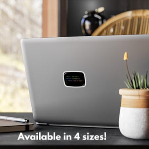 May include: A black sticker with a white border, displaying green, blue, and red text that reads "//Don't, Just Don't, function something() { return 'PLAY NO GAME'; }". The sticker is on a laptop.