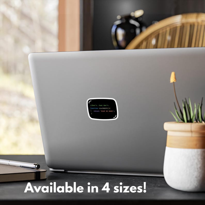 May include: A black sticker with a white border, displaying green, blue, and red text that reads "//Don't, Just Don't, function something() { return 'PLAY NO GAME'; }". The sticker is on a laptop.