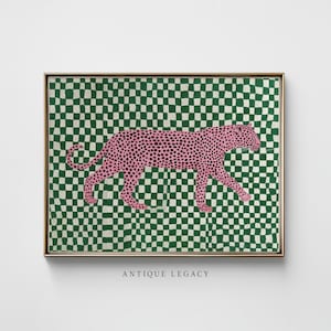 May include: Framed art print depicting a pink leopard with black spots on a green and white chequered background. The artwork is in a gold frame and has the text "ANTIQUE LEGACY" at the bottom.