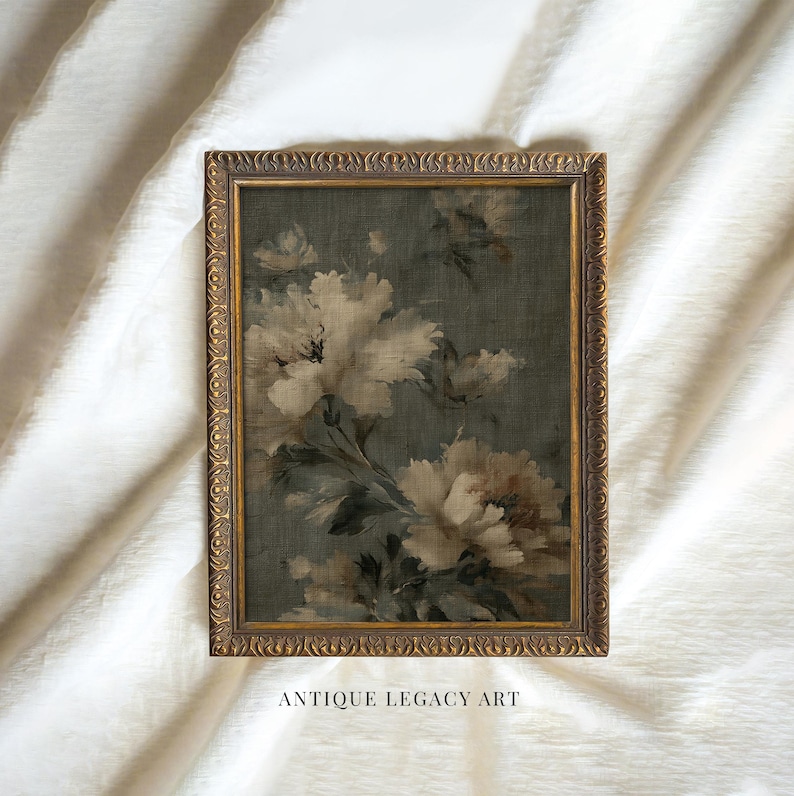 Op de afbeelding: Een antiek bloemenschilderij in een gouden, sierlijke lijst. Het kunstwerk toont grote, witte en beige bloemen tegen een donkergroene achtergrond. De tekst "ANTIQUE LEGACY ART" staat onderaan de lijst.