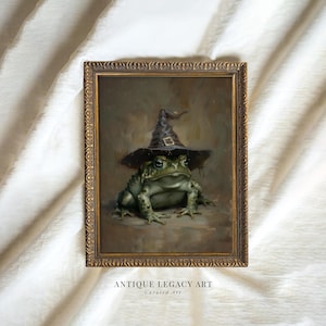 May include: A framed painting of a green toad wearing a black witch hat with a gold buckle. The artwork has a vintage aesthetic, with the words "ANTIQUE LEGACY ART" and "Curated Art" printed at the bottom.