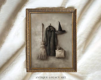 May include: Framed artwork featuring a witch-themed still life. A dark coat hangs on a hook next to a witch's hat and a beige tote bag. A broom leans against the wall. The frame is gold with ornate detailing. Text at the bottom reads "ANTIQUE LEGACY ART Curated Art."