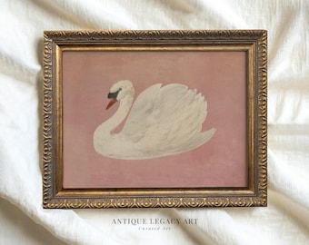 May include: A vintage framed print of a white swan on a pink background. The swan is depicted in a graceful pose with its head turned to the side. The frame is ornate and gold in color.