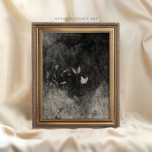May include: An antique framed print featuring a grayscale image of butterflies and foliage. The artwork is set against a dark background, with the text "ANTIQUE LEGACY ART" at the top and "Curated Art" at the bottom. The frame has a gold finish.