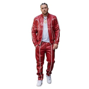 May include: A red leather track suit with white trim. The jacket has a bomber style with a zipper closure. The pants have a drawstring waist. The suit is worn with a white t-shirt and white sneakers. The text "POGA JANI" is visible on the jacket.