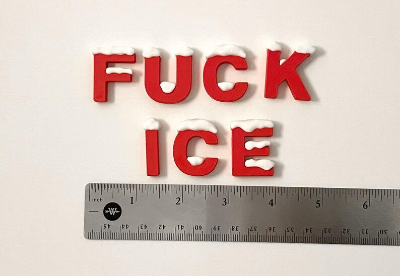 Pu&ograve; includere: Lettere rosse che compongono la scritta "FUCK ICE" con accenti di neve bianca in cima. Un righello di metallo con misure in pollici &egrave; sotto le lettere. Le lettere sono alte circa 2,5 cm.