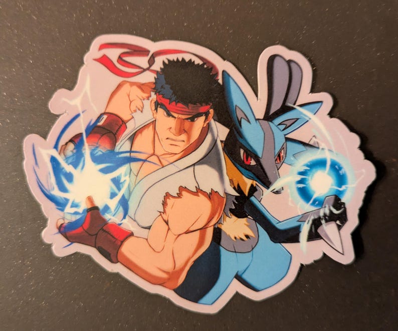 May include: A sticker featuring two characters, one from Street Fighter and the other from Pokemon. The Street Fighter character is a muscular man with a red headband, and the Pokemon character is a blue and black Lucario. Both characters are emitting blue energy.