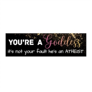 May include: A black rectangular sign with gold glitter accents and white text that reads "YOU'RE A Goddess" in a cursive font. Below, it says "it's not your fault he's an ATHEIST".
