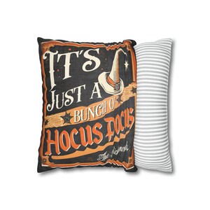 May include: A black and orange pillow with the text "It's Just A Bunch Of Hocus Pocus" and a witch's hat graphic. The pillow is paired with a gray and white striped pillow.