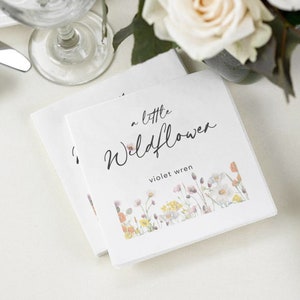 May include: Two white folded napkins with a floral design and the text "a little Wildflower violet wren".