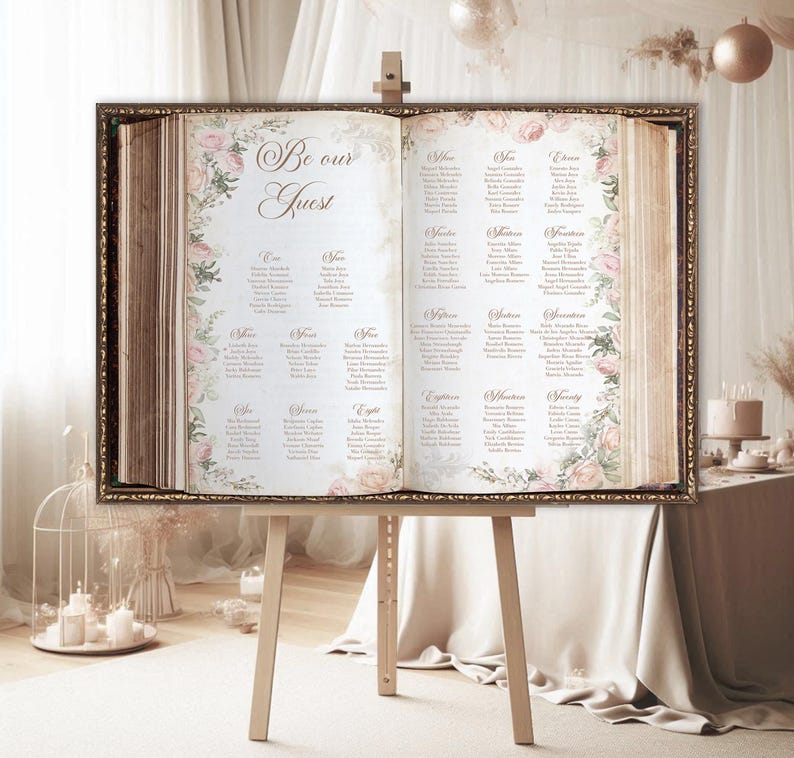 May include: A vintage-style wedding seating chart displayed on an easel. The chart is printed on a cream-colored background with a floral design and the words "Be our Guest". The chart lists guest names and table assignments.