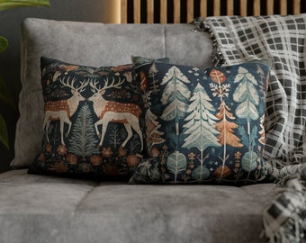 May include: Two decorative throw pillows with a dark blue background and a woodland pattern. One pillow features a pair of deer in a forest scene, while the other pillow features a forest scene with trees and flowers.