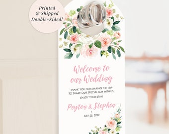May include: A white door hanger with a floral design and the text "Welcome to our Wedding" with the names Peyton & Stephen and the date July 25, 2022.