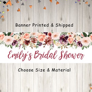 Op de afbeelding: Een witte banner met een bloemige rand in tinten roze, bordeauxrood en groen. De tekst "Emily's Bridal Shower" is geschreven in bordeauxrode cursieve letters. De banner bevat ook de tekst "Banner Printed & Shipped" en "Choose Size & Material".