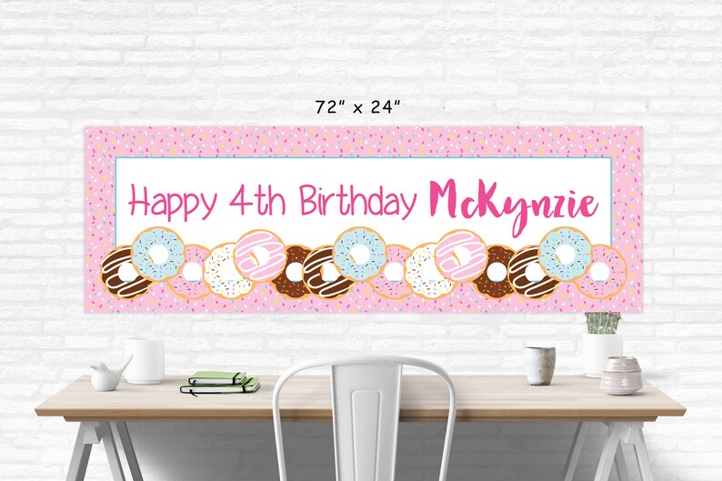 Op de afbeelding: Roze en witte donut-thema verjaardagsbord met de tekst "Happy 4th Birthday McKenzie" en een rij kleurrijke donuts met sprinkles.