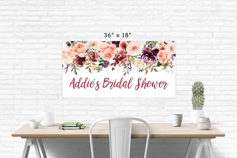 Op de afbeelding: Een witte bruidsdouchebanner met een bloemenkrans van roze, bordeauxrode en witte bloemen. De banner heeft de tekst "Addie's Bridal Shower" in bordeauxrode letters. De banner is 91,44 cm bij 45,72 cm.