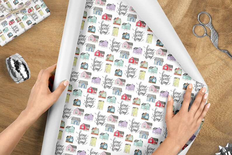 May include: White wrapping paper with a repeating pattern of colorful houses and the text "home sweet home" in black script.