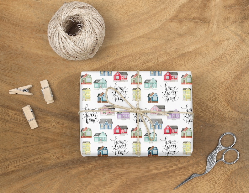 May include: White wrapping paper with a repeating pattern of colorful houses and the text "home sweet home".