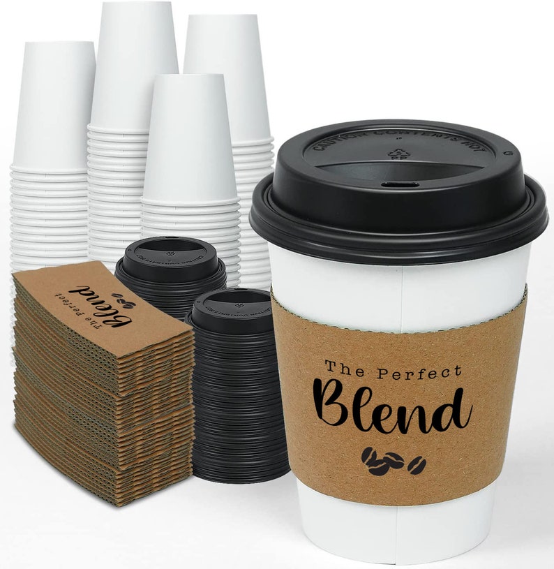 May include: White paper coffee cups, black lids, and cardboard sleeves with the text "The Perfect Blend" and coffee bean graphics. Stacks of cups and sleeves are visible, suggesting a bulk purchase.