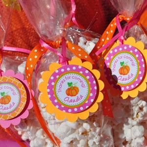 May include: Orange and pink favor bags filled with popcorn and decorated with a scalloped circle tag that says "Thanks for coming! Claudia".