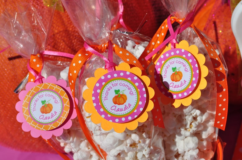 May include: Orange and pink favor bags filled with popcorn and decorated with a scalloped circle tag that says "Thanks for coming! Claudia".