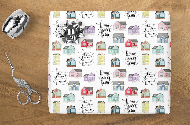 May include: White wrapping paper with a repeating pattern of colorful houses and the text "home sweet home" in black script.