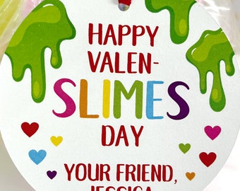 May include: A round white tag with green slime dripping down the sides. The tag says "Happy Valen-Slimes Day" in rainbow letters and "Your Friend, Jessica" in red letters. There are small hearts in various colors around the text.