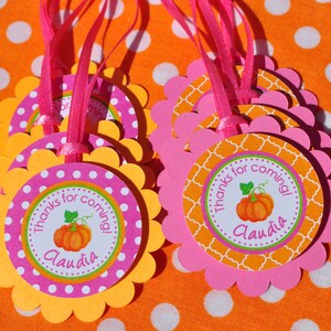May include: Orange and pink favor tags with scalloped edges. The tags feature a pumpkin design and the text "Thanks for coming! Claudia".