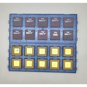 May include: A blue plastic tray holding ten Intel 486 DX computer processors. The top row displays the dark brown tops of the chips with white Intel 486 DX branding, while the bottom row shows the gold-colored pin grid array undersides.