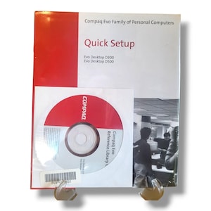 May include: A Compaq Evo Family of Personal Computers Quick Setup guide. The cover is white with red accents and the text "Quick Setup". Includes a CD-ROM with the Compaq logo and "Reference Library".