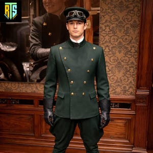 May include: A dark green uniform with gold buttons, a high collar, and black gloves. The uniform includes a matching hat with goggles. The person is standing in front of a wooden wall with a painting.